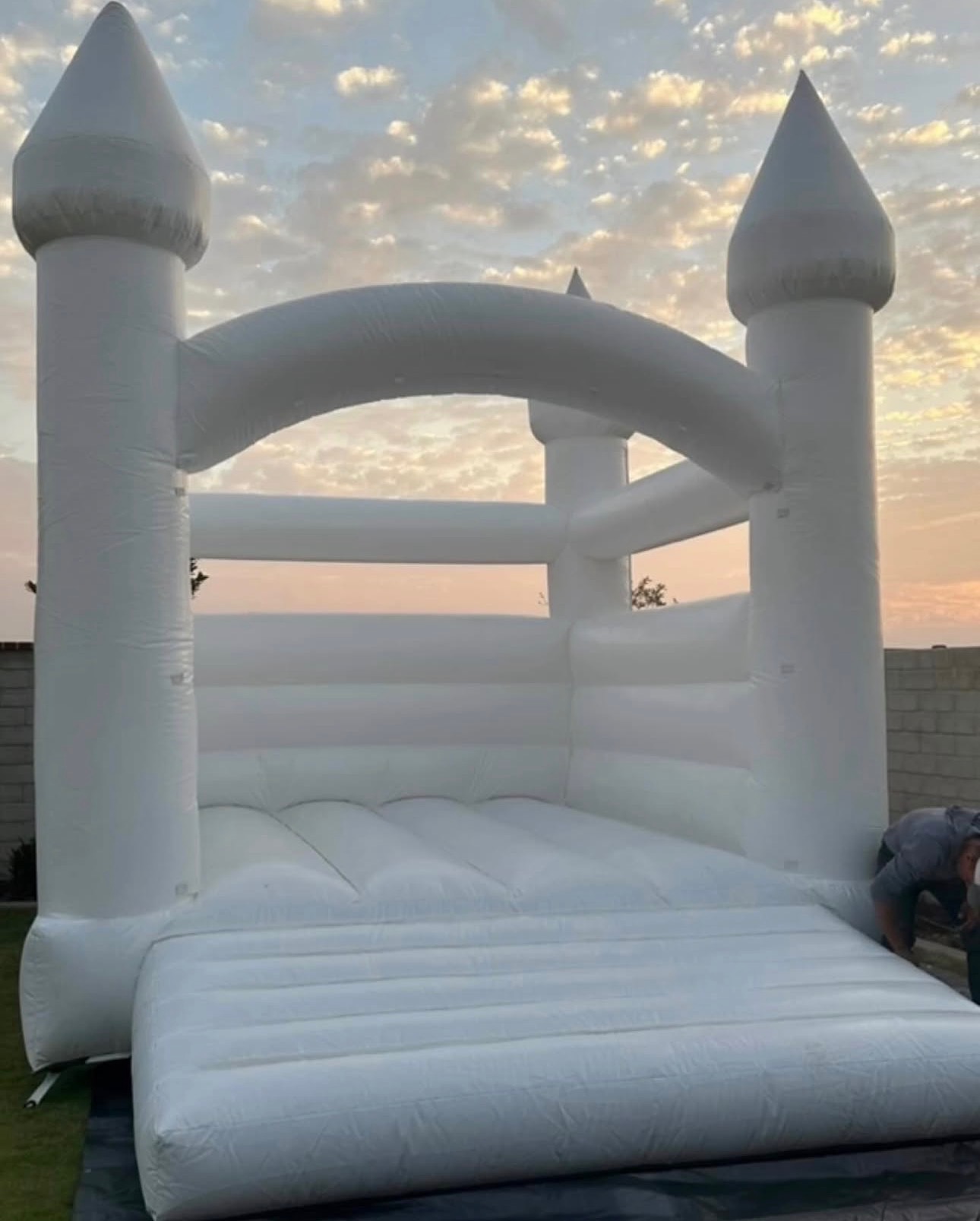 All-white wedding bounce house at sunset
