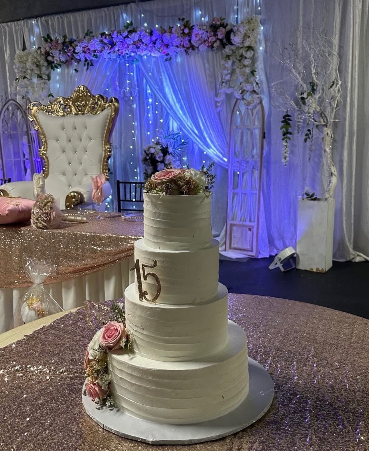 Quinceañera tiered cake with throne and floral backdrop